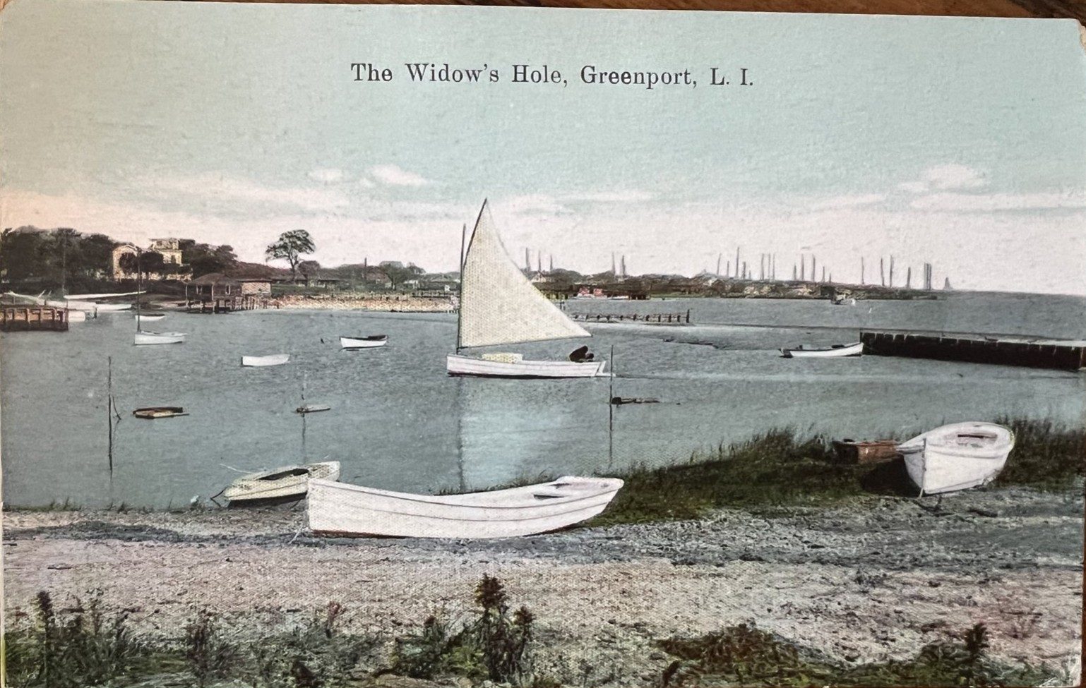 Hand-colored postcard of Widow's Hole with a sailboat and rowboats, circa 1910