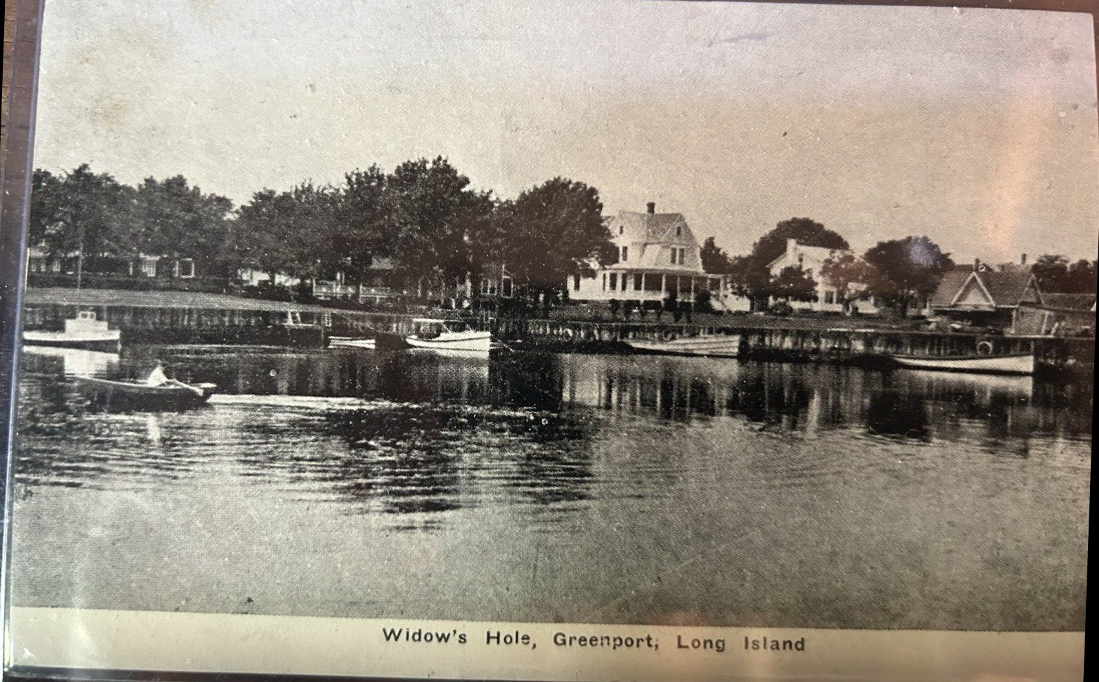 Postcard: Widow's Hole shoreline with launches along the bulkhead