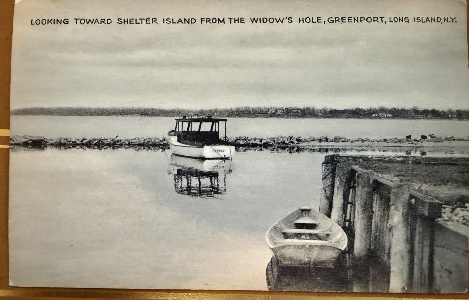 Vintage postcard: Looking toward Shelter Island from the Widow's Hole, with a launch moored inside the rock jetty