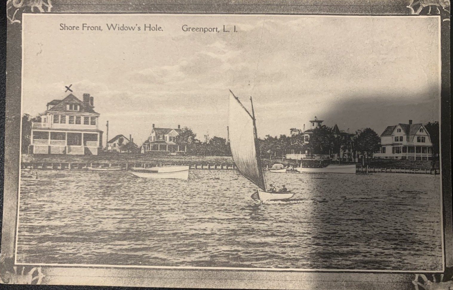 Ornate-bordered postcard: Shore Front, Widow's Hole with sailboat
