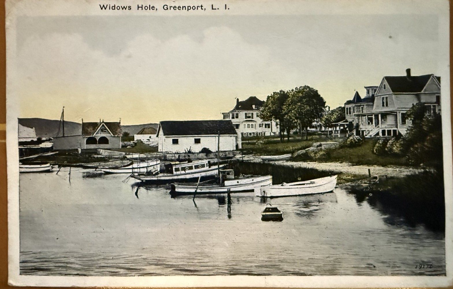 Hand-colored postcard: Widows Hole with houses and many boats hauled on shore